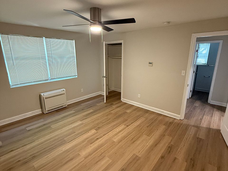 Bedroom w/ new ceiling fan, floors, windows, and new mini-split A/C & heating unit.