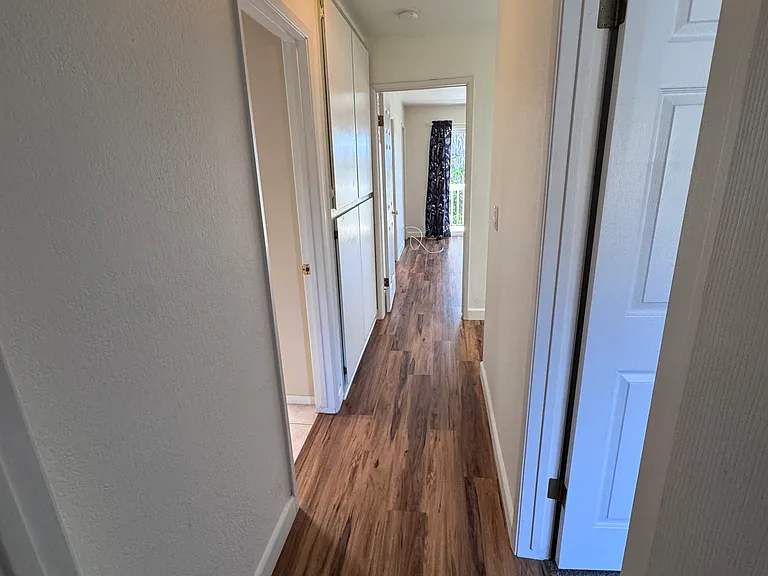 Upstairs hallway leading to primary suite from 2nd bedroom