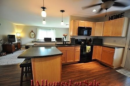 Kitchen with maple cabinets and beautiful rustic laminate flooring. Open into Living Room.