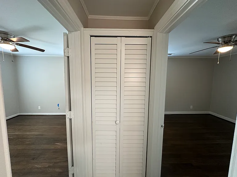 Hallway looking toward linen closet with both bedroom doors open.