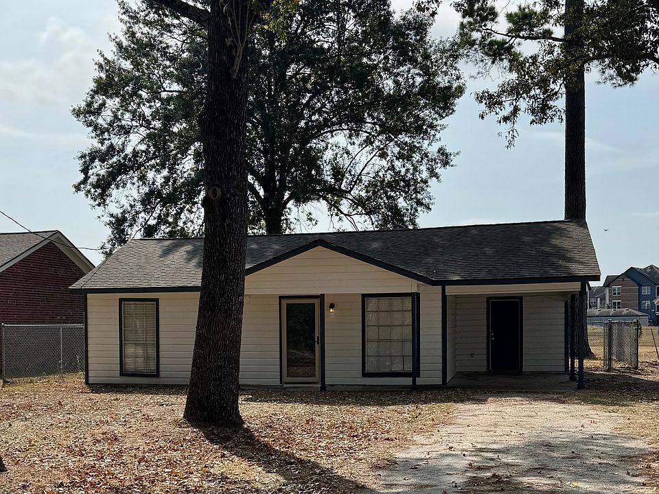 Front view of home set off of the road with a long driveway.