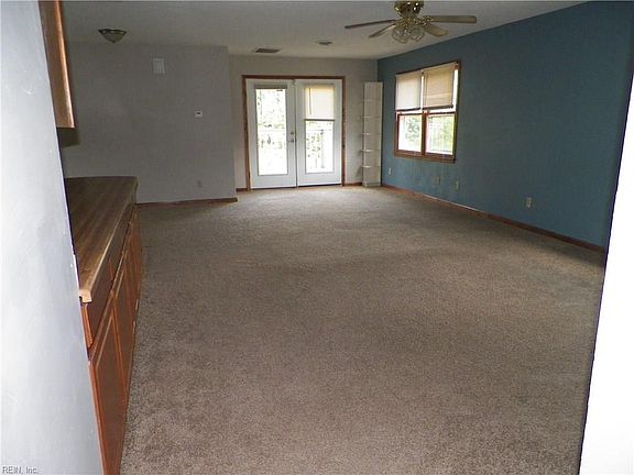Looking from upstairs hallway into family room towards double doors to deck