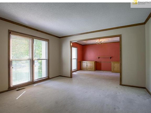 Floor to ceiling thermal pane windows with blinds opening into formal dining perfect for large groups.