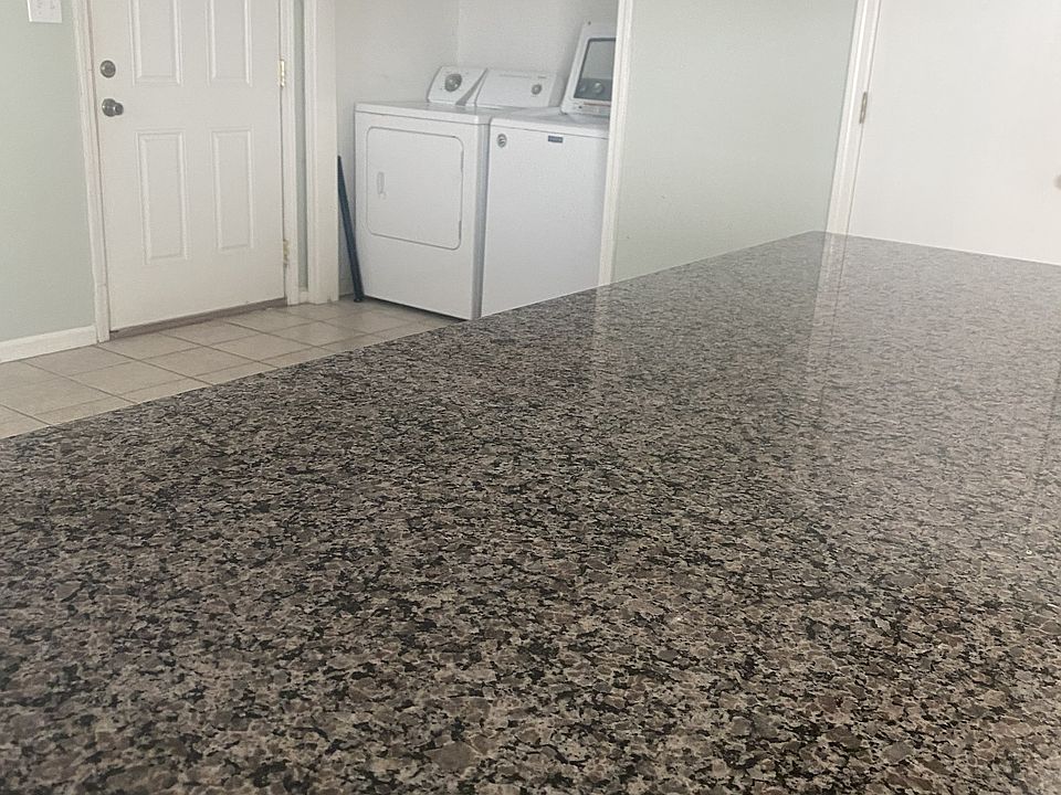 Kitchen granite countertop and utility closet.
