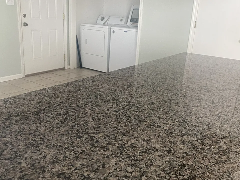Kitchen granite countertop and utility closet.