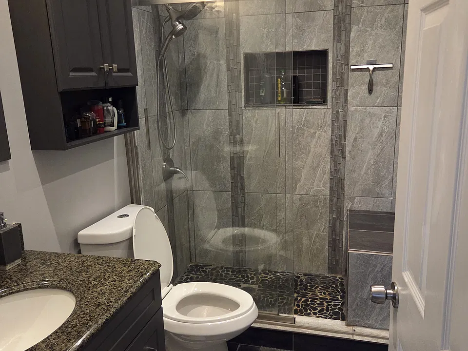 Master bathroom with granite top and walk-in shower with a seat.