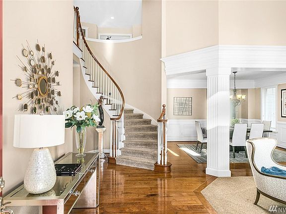 Gorgeous grand entry with view of curved staircase, formal living room and vaulted ceilings