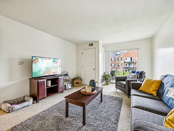 Relax in a bright, spacious living room with modern furnishings at University Hills Apartments near the University of Toledo