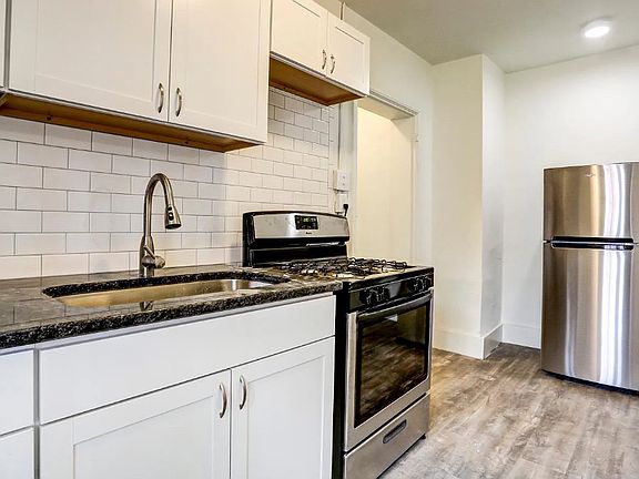 Updated kitchen with gas stove, granite countertops, and vinyl floors