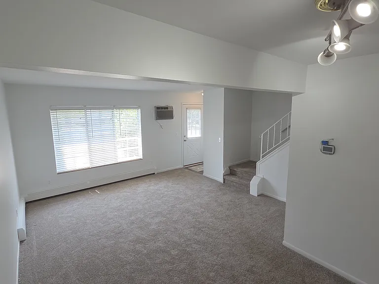 Large living room with private entrance, natural light, and access to the second level.