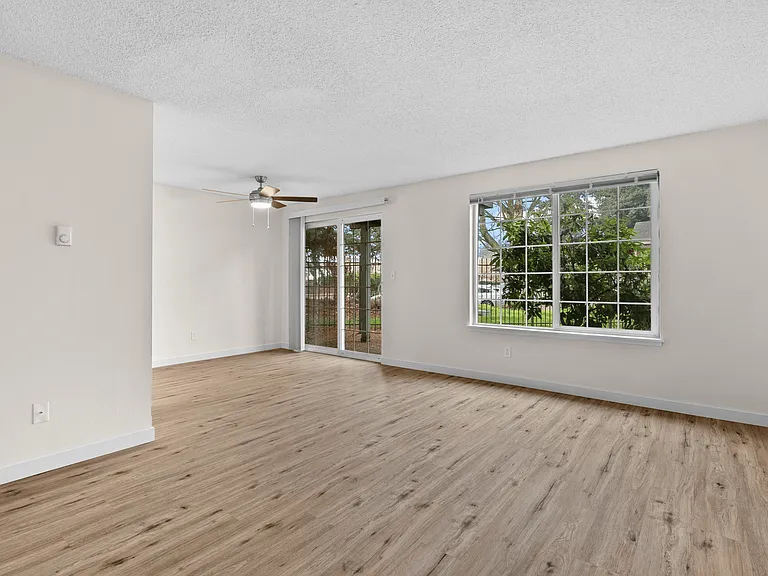 Open living area with natural light and patio access. Open living area with natural light and patio access.
