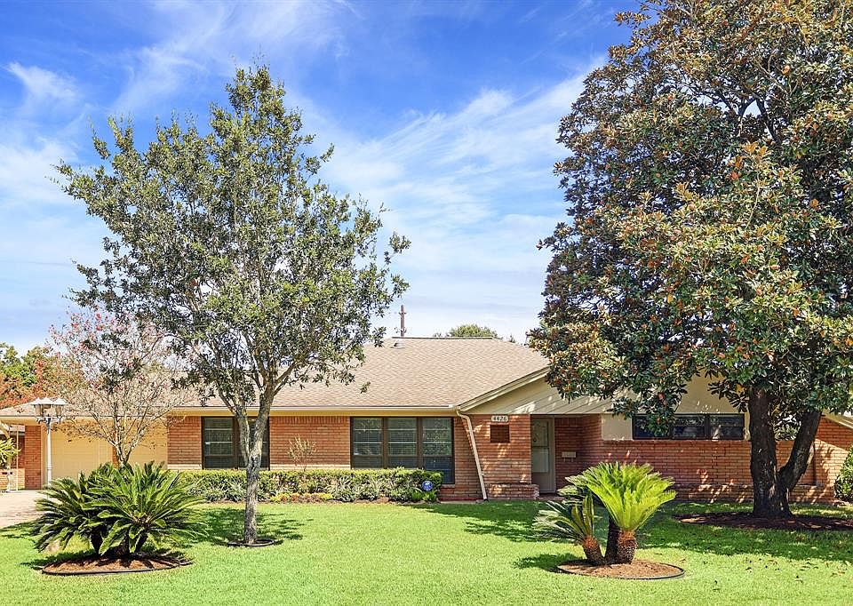 Front elevation: Mid century cues include the brick selection and period appropriate column. Neat landscaping and double wide driveway.