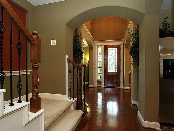 A gorgeous leaded front door with side light & crown molding opens to the two story entry with beaut