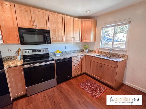 Updated kitchen with newer appliances and granite countertops. A pantry is just out of view.
