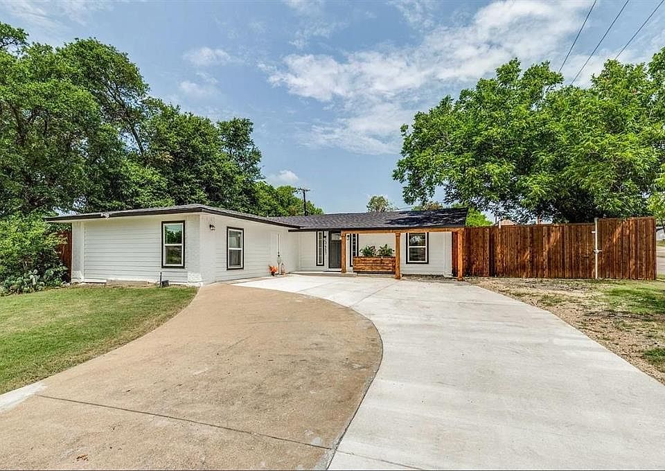 Ranch-style house featuring solar panels and concrete driveway