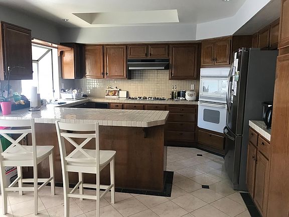 Kitchen area with lots of counter space and cabinets for storage. Barstool area for breakfast or dining