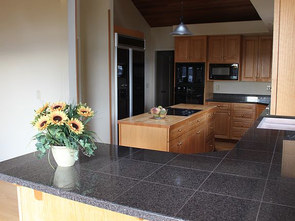 Large kitchen with granite counter tops.
