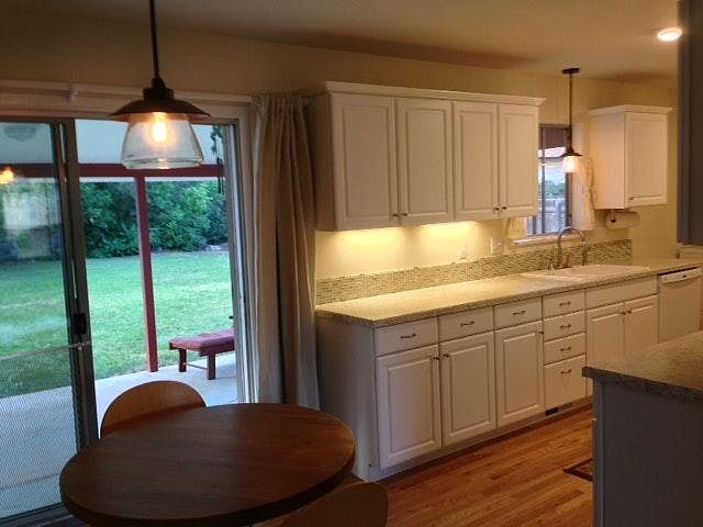 Covered patio off kitchen with fenced, park-like backyard.