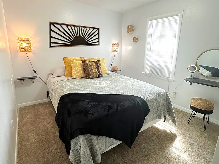 Bedroom with queen size bed and make-up vanity.