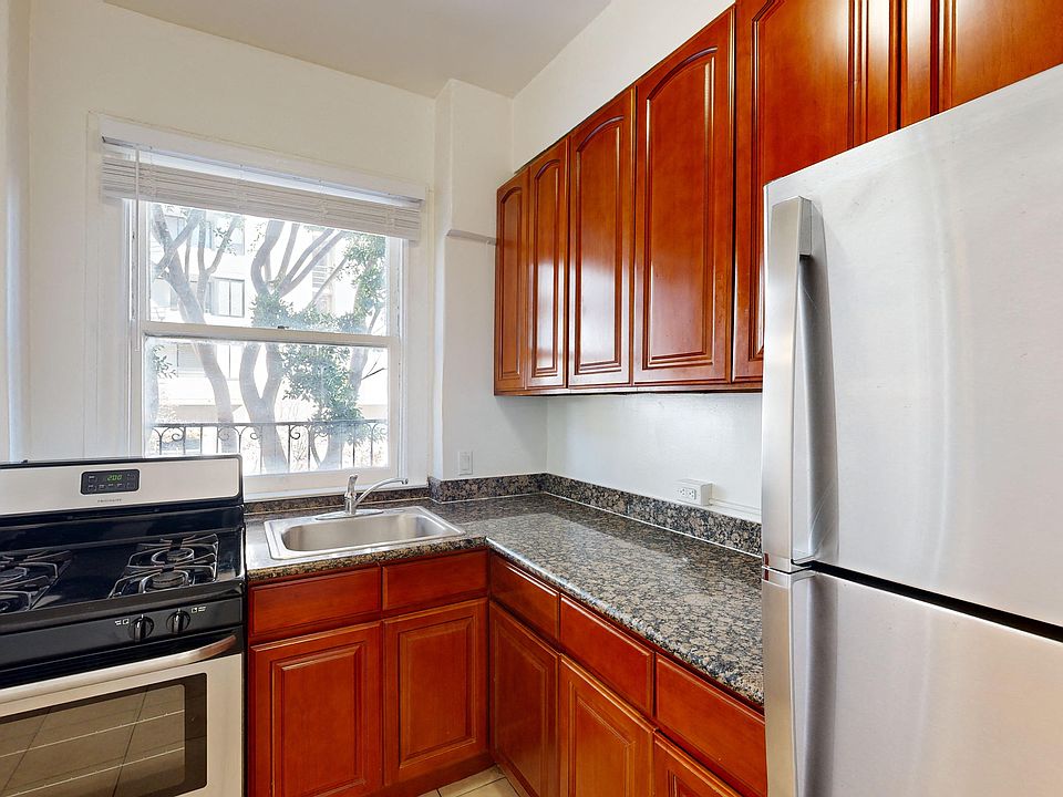 Kitchen with multiple cabinets, refrigerator, stove, and sink