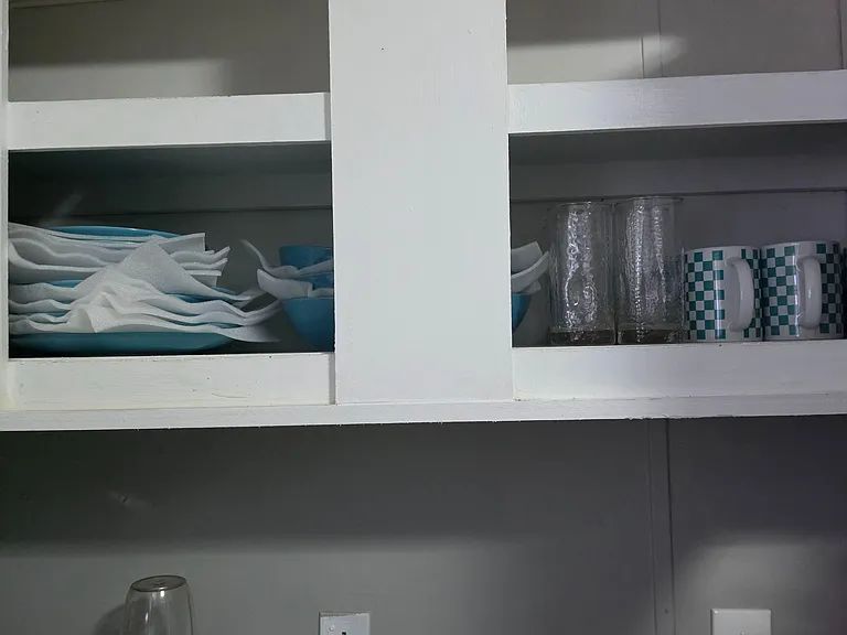 Open shelving in the kitchen keeps everyday dishes and glassware within easy reach above the countertop.