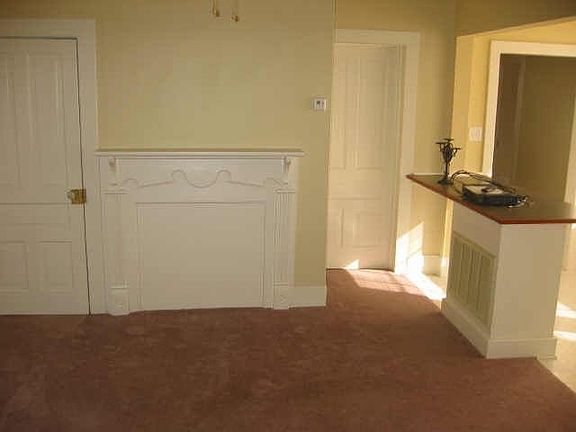 Living room with carpet floor and mantle place