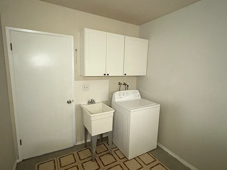 The dryer and sink with a door to enclose the stove and the dryer/ washer machine