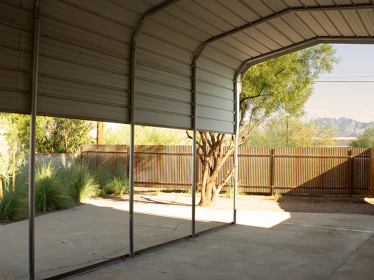 Covered parking with private driveway and additional outdoor space.