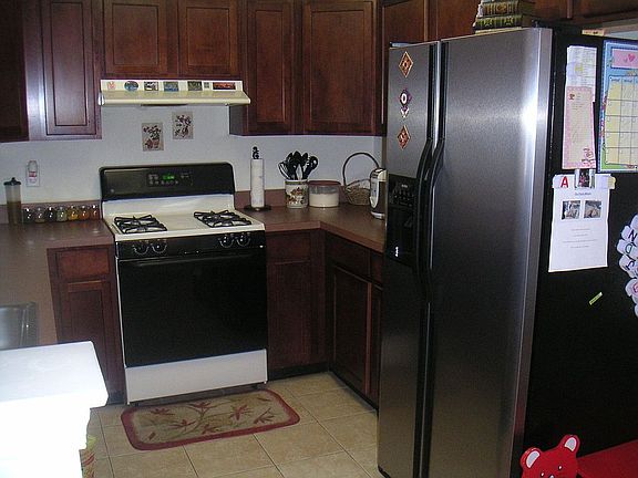Kitchen features custom cabinets, premium appliances and ceramic flooring