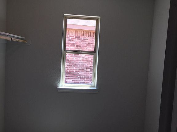 Laundry room with window and lots of storage, with adjacent 