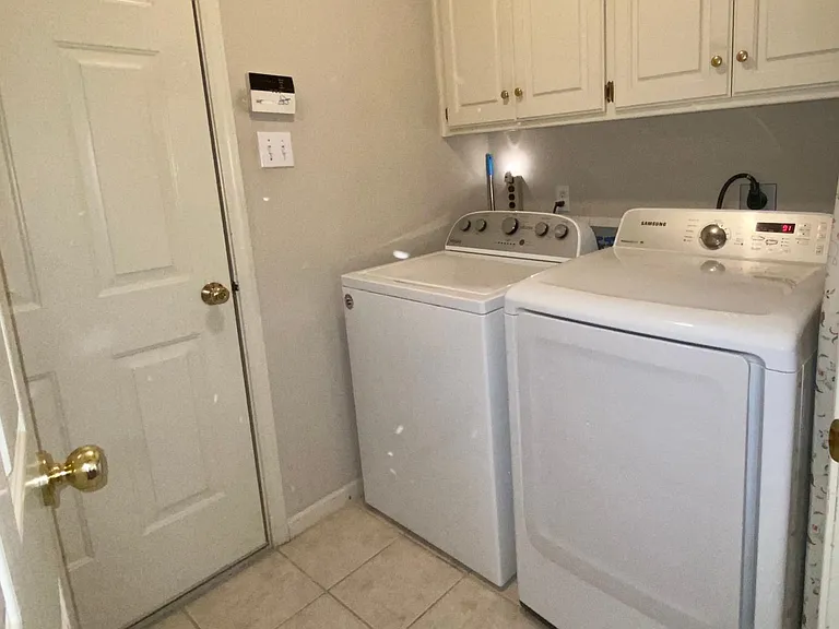Laundry Room with extra storage closet and upper cabinets.