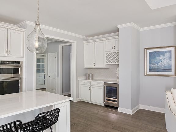 Optional Beverage Center with white cabinets, tile backsplash, wine refrigerator and wine storage ar