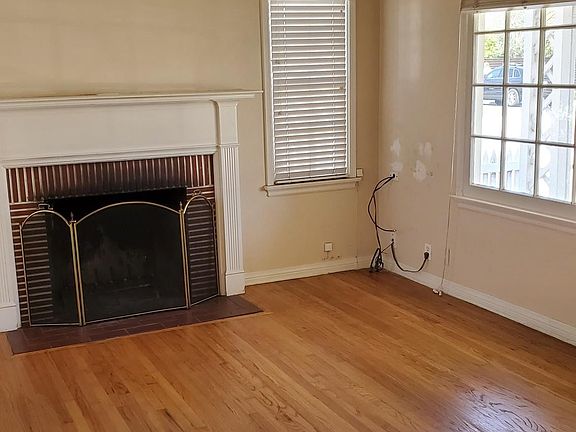Living room with wide front window, fireplace, hardwood floors