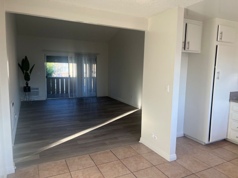 We are in the dining room area, overseeing the kitchen to the right and the living room in front