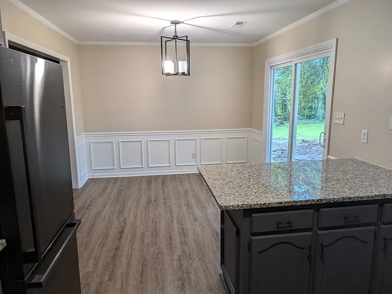 Kitchen island and dining area with new light, fresh paint, and sliding doors to the backyard (with new patio)