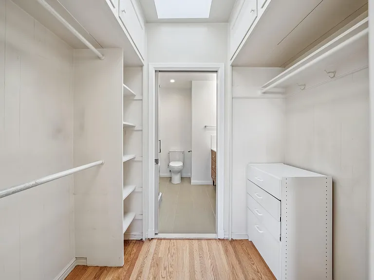 Primary bedroom closet leading to ensuite bathroom