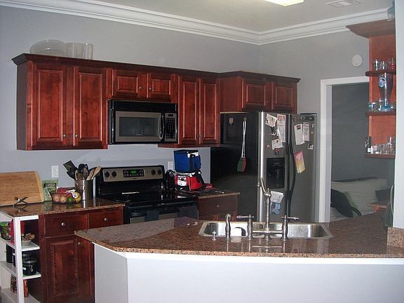 Kitchen with dark cabinetry, granite counter tops & stainless steel appliances