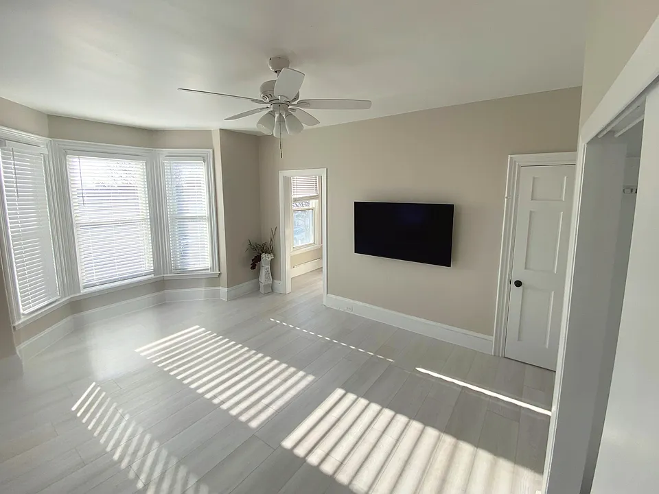 A spacious living area offering a large storage closet and a dedicated wall ideal for mounting a TV, designed for comfortable, clutter-free living.