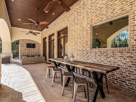 French Doors lead to this grand covered patio. Fantastic covered space overlooks pool/spa. Look at the beautiful wood ceiling treatment.