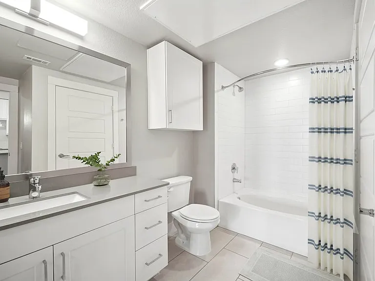 Finish Package II bath with grey quartz countertops and white cabinetry