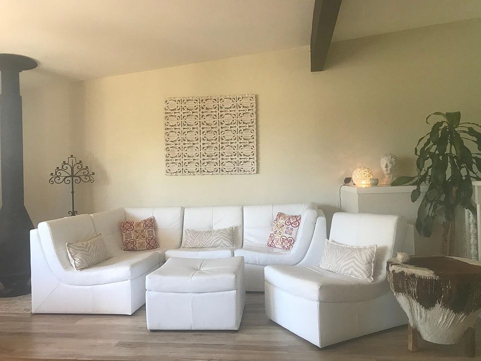 Gorgeous living room with dramatic wood beams and wood burning stove on top floor. Beautiful, private, and cozy.