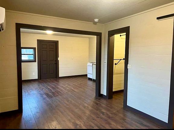 View from bedroom looking at closet door and living/kitchen area