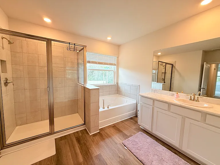 Master Bathroom with tub and shower and two separate vanities and private water closet.