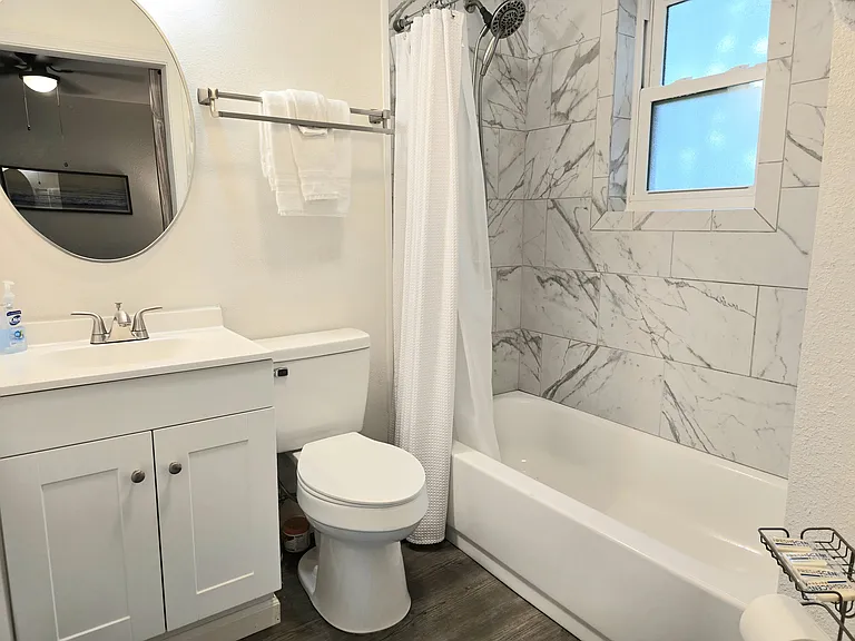 The bathroom has a porcelain tub with a new window. The magnetic showerhead can be hand held.