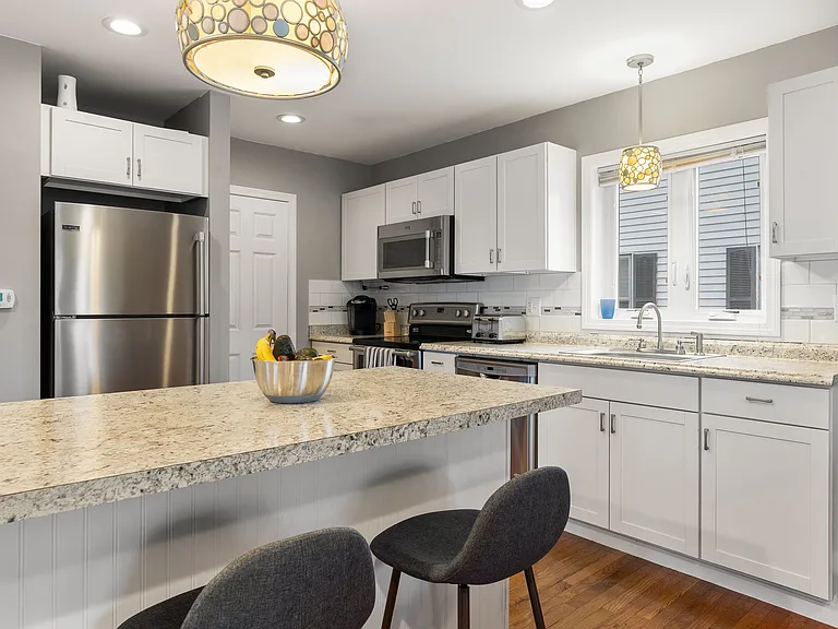 Full Kitchen View, Dishwasher, Built-in Microwave, Stainless Steel Refrigerator, Dining Area, Hardwood Flooring, Kitchen Island with Seating.