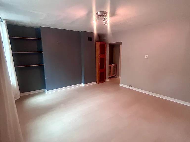 Bedroom is in the front of the house. There's built-in storage but no full length closet; plenty of space for an armoire. (Photo taken from front door entry).