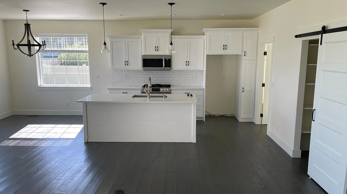Kitchen with dining area on the left and living room in front. Laundry room off the kitchen to the right. Walk in pantry sliding barn door on the right. - 175 Taelor Rd