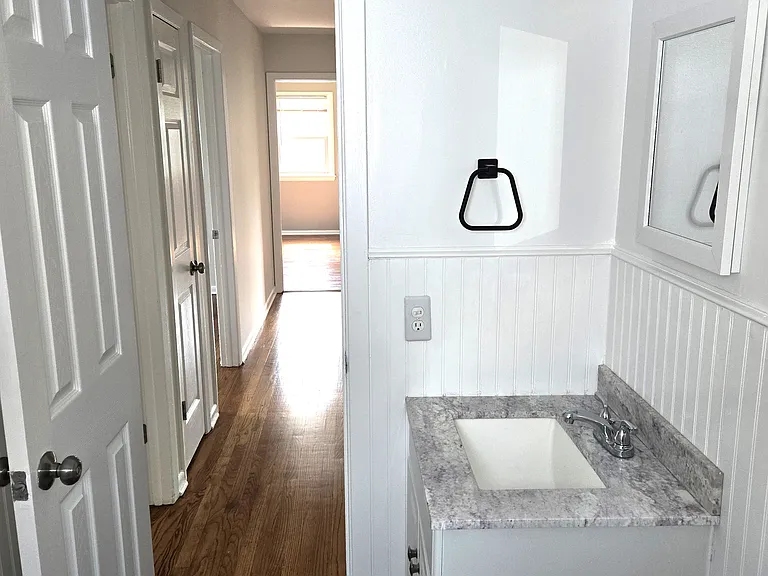 Modern vanity and classic wainscoting with tile floors.