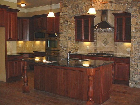 Kitchen features this arched stonework over the stainless venthood & cooktop.