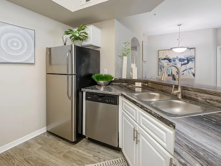 Experience culinary delight in your upgraded kitchen featuring modern stainless steel appliances, spacious cabinets, and a dedicated laundry area, blending style with convenience for luxurious living.